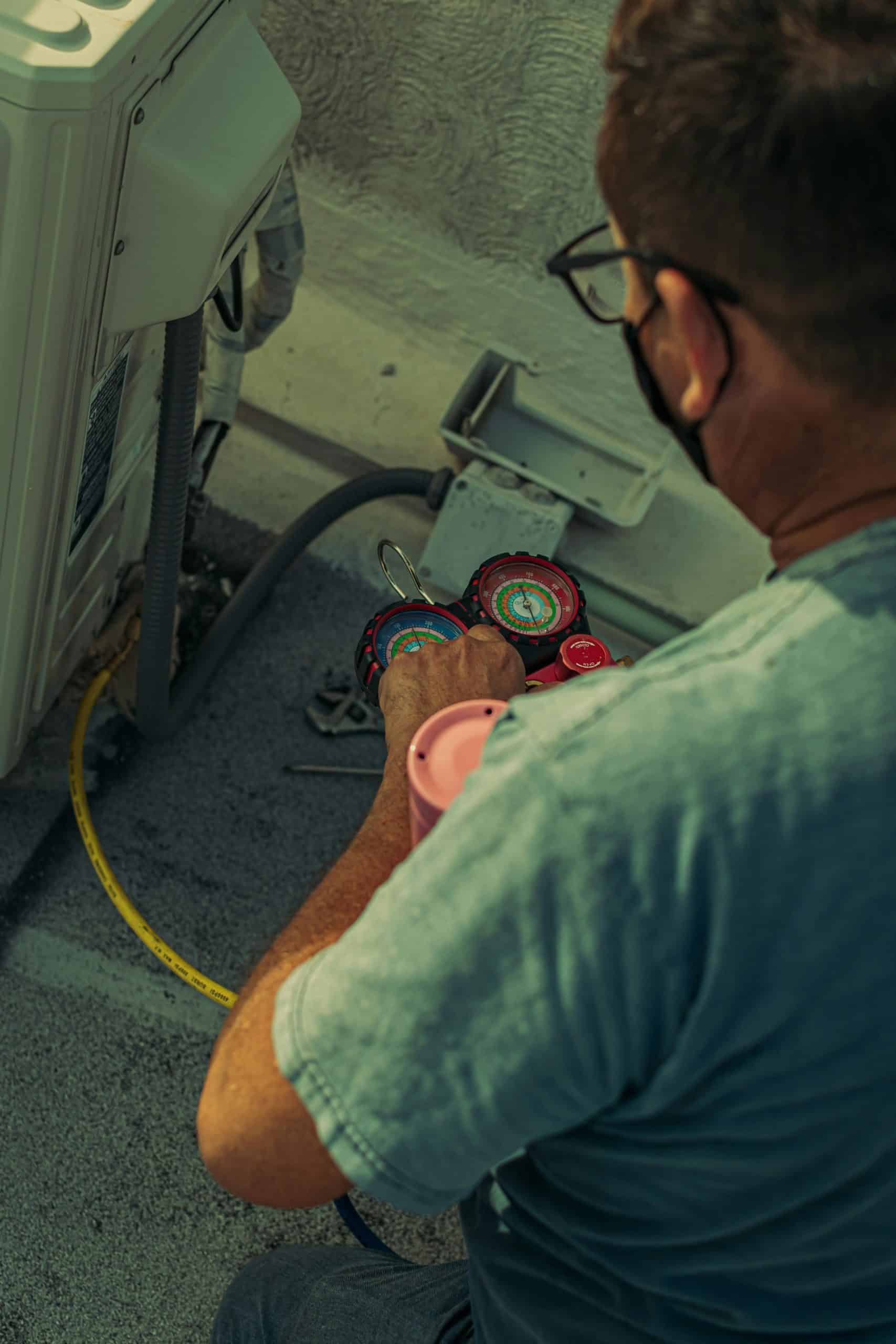 HVAC technician checking refrigerant pressure — reduce ServiceTitan payment processing fees for contractors
