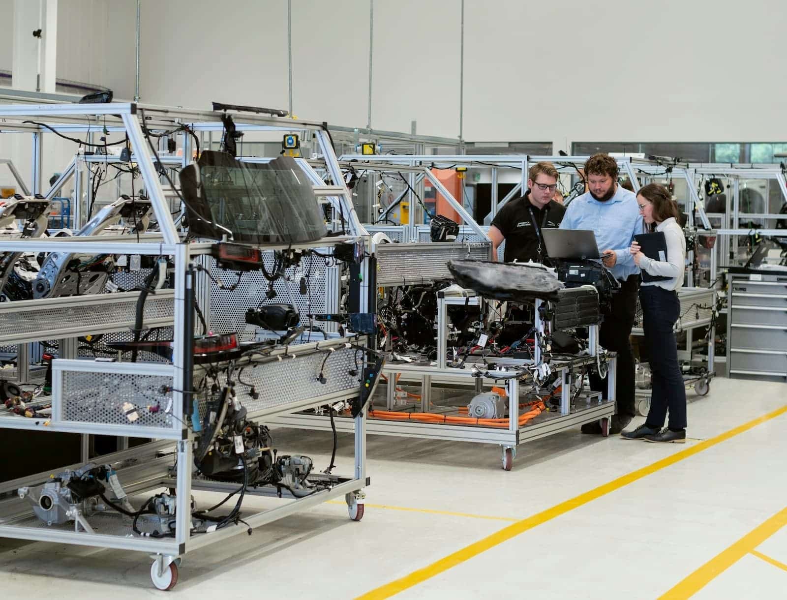 AmEx direct merchant agreement threshold — third-generation commercial wholesale operator reviewing volume data at industrial machinery, the kind of mid-market business that triggers the OptBlue conversion conversation