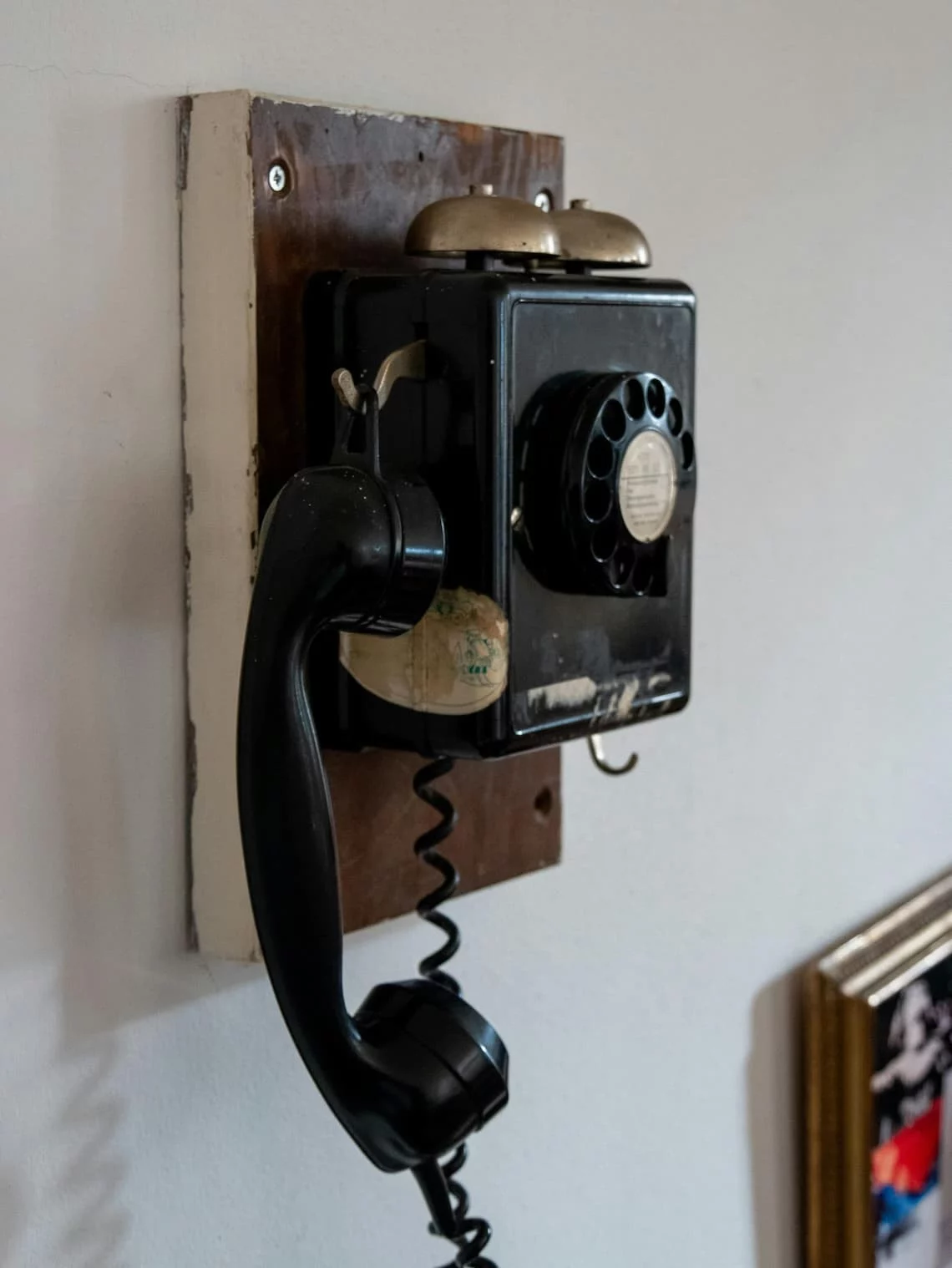 Payment processor retention call — vintage black rotary wall phone with twin bells, the visual register of the call merchants dread when they give notice
