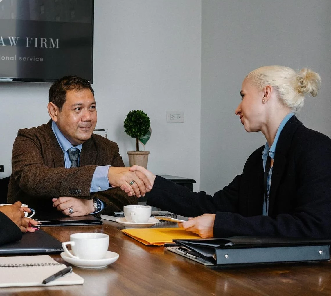 Law firm payment processing meeting with a handshake over a trust and operating account agreement
