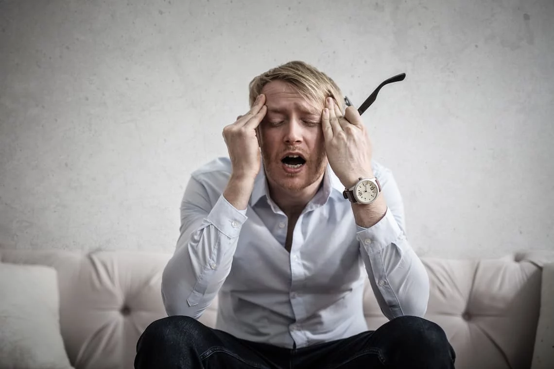 A homeowner frustrated by property tax payment problems sits with his head in his hands