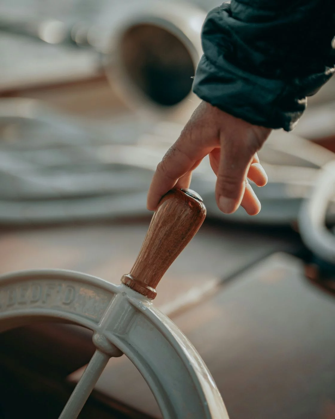 A hand gripping a ship's wheel handle to change course — the moment of switching back to a merchant account